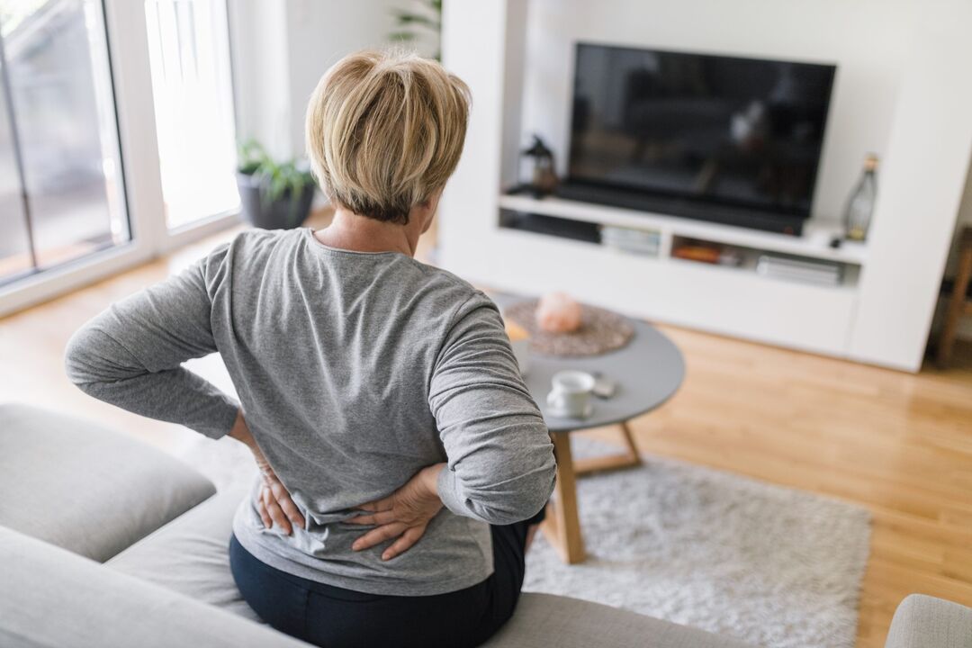 A woman worries about back pain in the lumbar region